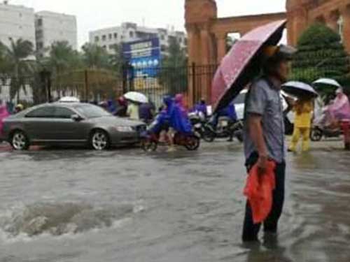 海口老人冒雨坚守示警 一站就是一小时多